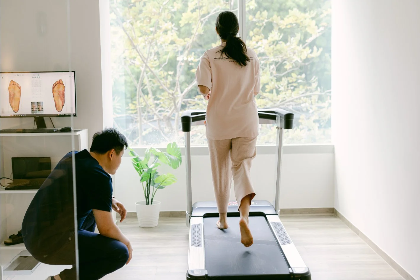 Podiatrist performing gait assessment on treadmill