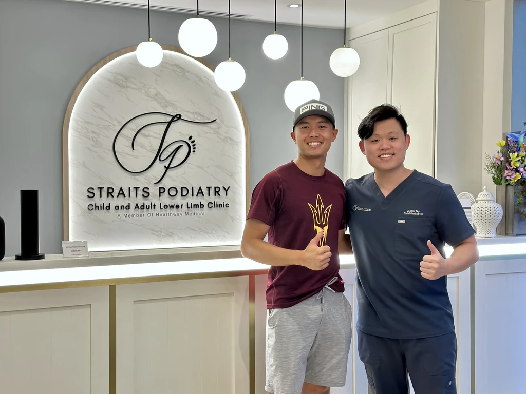 A patient with Mr Jackie Tey at the Straits Podiatry reception after a podiatry consultation