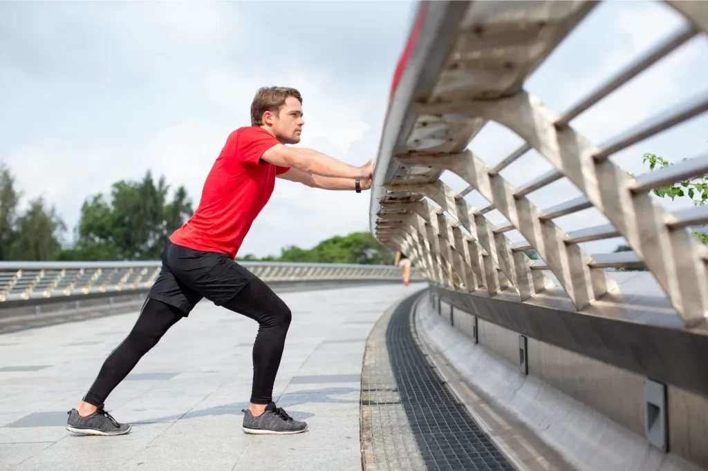 Man performing calf stretches for managing plantar fasciitis