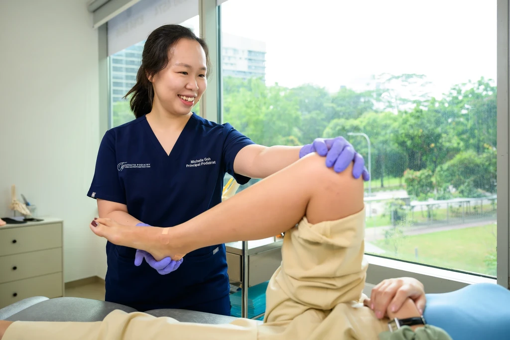 Ms Michelle Goh assessing a patient's knee and lower limb at Straits Podiatry as part of a biomechanics consultation