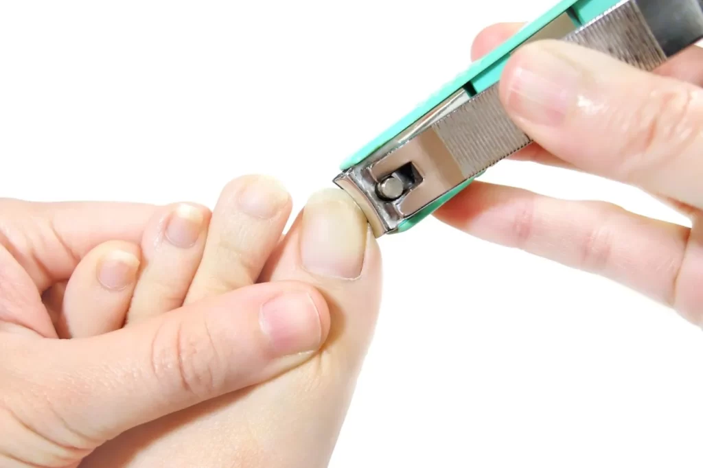 Person cutting toenail to manage ingrown toenail