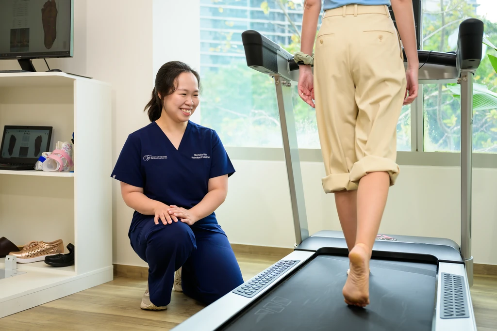 Ms Michelle Goh, Principal Podiatrist, observing a patient walk barefoot on the treadmill during a gait assessment.