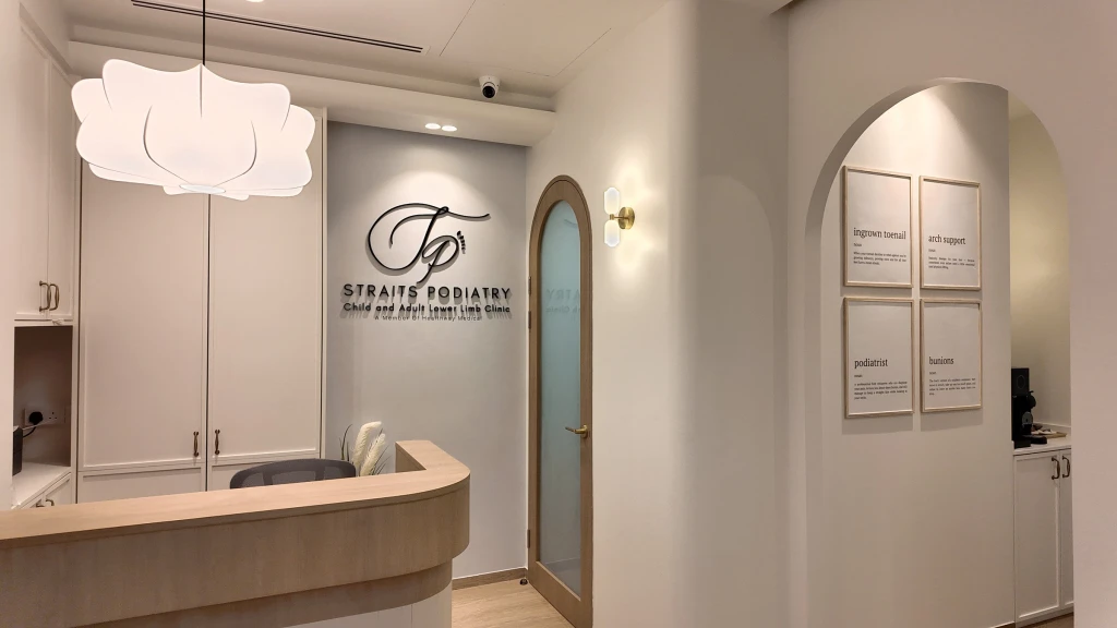 Interior reception of the Straits Podiatry clinic with the logo wall and framed foot-term definition prints